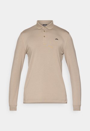 Gaišais garo piedurkņu polo krekls, izgatavots no viegla auduma. Tam ir klasiskā apkakle, trīs pogu slēdzis un neliels melns logo uz krūtīm.