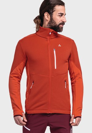 Rote Softshell-Jacke mit hohem Kragen, gerippter Textur, weißen Reißverschlusstaschen und kontrastierenden Ärmeln.