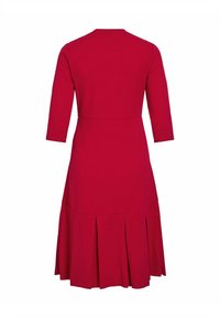 Robe rouge longueur genou avec manches trois-quarts et détail jupe plissée, vue de dos sur fond blanc.
