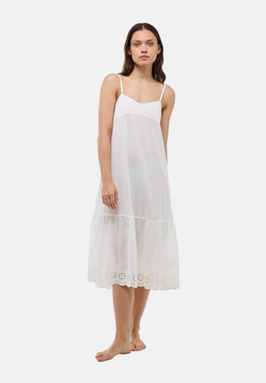 Robe en coton blanc avec des fines bretelles, un décolleté en V et un ourlet à volants orné d'accents floraux brodés en bas.