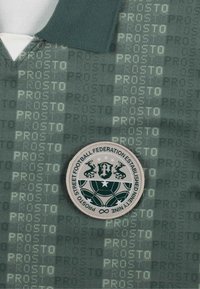 Ciemnozielona koszulka piłkarska z teksturowanym wzorem z napisem "PROSTO". Okrągła naszywka przedstawia piłkę nożną oraz herb.