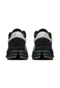 Baskets de sport noires et grises avec une semelle rembourrée, une tige en maille et un design de talon distinctif. Logo à l'arrière.