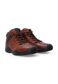 Brązowe skórzane buty typu high-top z czarnymi akcentami, teksturowanym wykończeniem, pomarańczowymi sznurówkami i solidną czarną gumową podeszwą. Posiadają metalowe oczka.