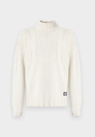 Μπεζ πουλόβερ από πλεκτό καλώδιο με ψηλό ριμπ ζιβάγκο, μακριά μανίκια και μικρό μαύρο λογότυπο κοντά στο τελείωμα.