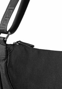 Borsa in tessuto nero con una superficie texture, dotata di una tasca con zip e una spallina spessa regolabile fissata da un morsetto metallico.