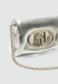 Borsa a mano in pelle argentata metallica con una texture liscia, dotata di un evidente clasp a forma di cerchio e di una tracolla in catena dorata.