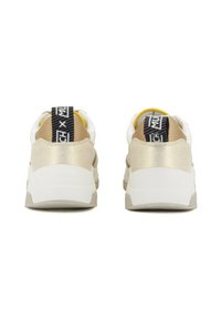 Sneaker beige e bianchi con una tomaia testurizzata, dettagli dorati, un'etichetta nera sul tallone e una suola spessa di colore chiaro.