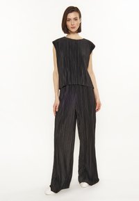 Set din două piese, negru, cu pliuri, compus dintr-un top cu mânecă scurtă și guler rotund, și pantaloni cu picioare largi. Textură netedă cu dungi verticale.