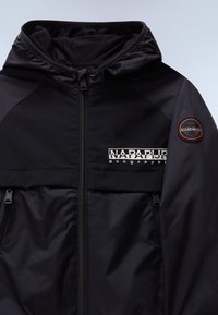 Μαύρο μπουφάν με κουκούλα από λείο ύφασμα, με φερμουάρ μπροστά, δύο πλαϊνές τσέπες, λογότυπο στο στήθος και υφασμάτινη εσωτερική επένδυση.