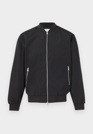 Μαύρο bomber μπουφάν με μπροστινό ασημένιο φερμουάρ, δύο τσέπες στο πλάι με φερμουάρ, ριμπ μανσέτες και ζώνη μέσης, εμφανιζόμενο σε απλό φόντο.