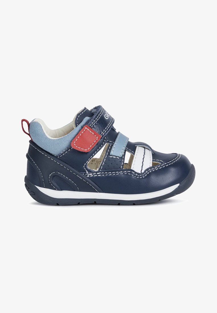 Chaussure en cuir bleu marine pour tout-petits avec des bandes Velcro, accents blancs et un bout texturé. Caractéristiques d'une semelle flexible et d'un design léger.