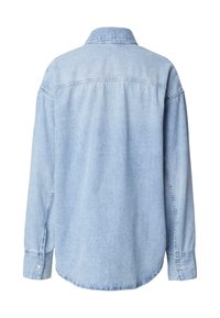 Camicia di jeans azzurro chiaro con maniche lunghe, polsini con bottoni e colletto. La parte posteriore presenta una cucitura a yoke e una vestibilità rilassata.