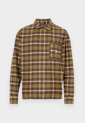 Camicia a quadri marrone in tessuto morbido, con chiusura frontale con bottoni, colletto piegato e taschino sul petto a sinistra con logo bianco.