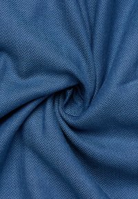 Tessuto a zigzag di colore blu scuro, con una texture liscia e una leggera lucentezza, elegantemente drappeggiato e torcigliato.