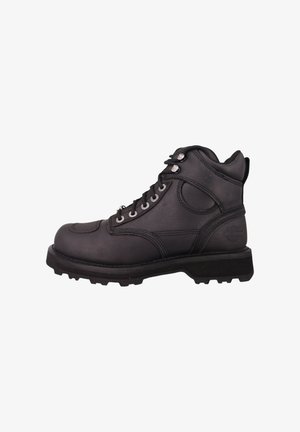 Bota de trabajo de cuero negro con cordones, cuello acolchado en el tobillo y suela de goma resistente, vista lateral sobre fondo blanco.