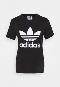 Svart bomullströja med korta ärmar, prydd med en stor vit Adidas-logotyp och tre horisontella ränder nedanför.