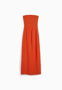 Orange strapless klänning med en smockad bodice och flödande kjol. Tillverkad av lättviktsmaterial med en sidenslits för ökad rörelse.