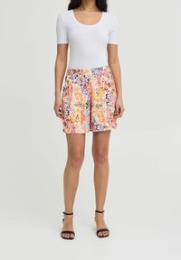 Barevné šortky s vzorem a elastickým pasem, zdobené víry oranžové, růžové a modré barvy, spárované s přiléhavým bílým topem.