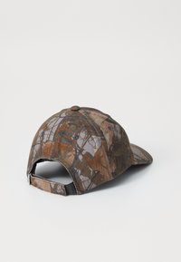 Camo baseball cap i brune og grå nuancer, med en buet skygge, justerbar rem og struktureret stof med et blade- og grenmønster.