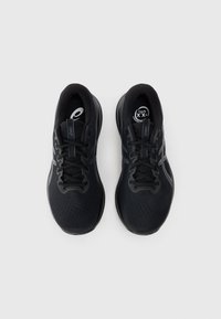 Zapatillas deportivas negras con parte superior de malla, punta redondeada y acentos en gris que contrastan. Cuentan con un cierre de cordones y una suela acolchada.
