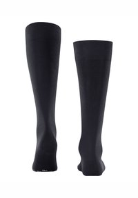 Chaussettes noires montantes avec bord côtelé et texture lisse. Elles présentent une forme ajustée et un renforcement au niveau du talon et des orteils pour plus de durabilité.