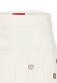 Geplooide crèmekleurige rok met metalen gouden stippen, met een gladde textuur en een tailleband met een rood label. Ritssluiting aan de achterkant.