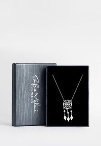 Sølv vedhængs halskæde med et cirkulært design, der har blomster mønstre og tre hængende diamantformede dekorationer, præsenteret i en sort æske.