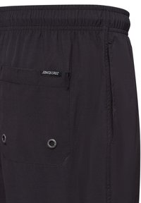 Zwarte shorts met een elastische tailleband, een achterzak met zwarte stiksels en een metalen oogje. Glad, lichtgewicht materiaal.