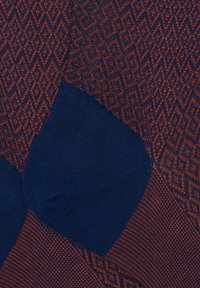 Calzini blu e marrone rossastro con motivo geometrico a diamante, texture liscia e rinforzi nelle aree del tallone e delle punte.