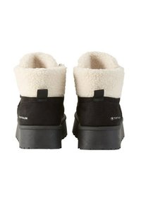 Zwarte suede enkelboots met een pluizige witte bontkraag, ribbelige antislipzolen en lusvormige aantrek lussen voor gemakkelijk aan- en uittrekken. Tom Tailor merknaam op de hak.