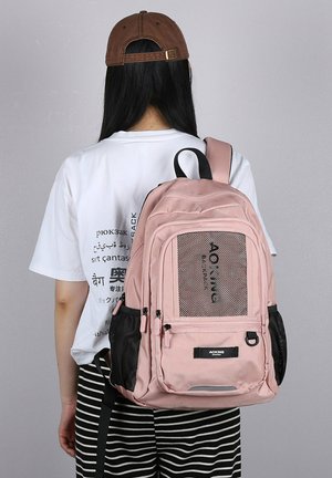 Zaino rosa con tasca frontale in rete testurizzata, scomparti con cerniera multipli, tasche laterali in rete nera e spallacci regolabili.