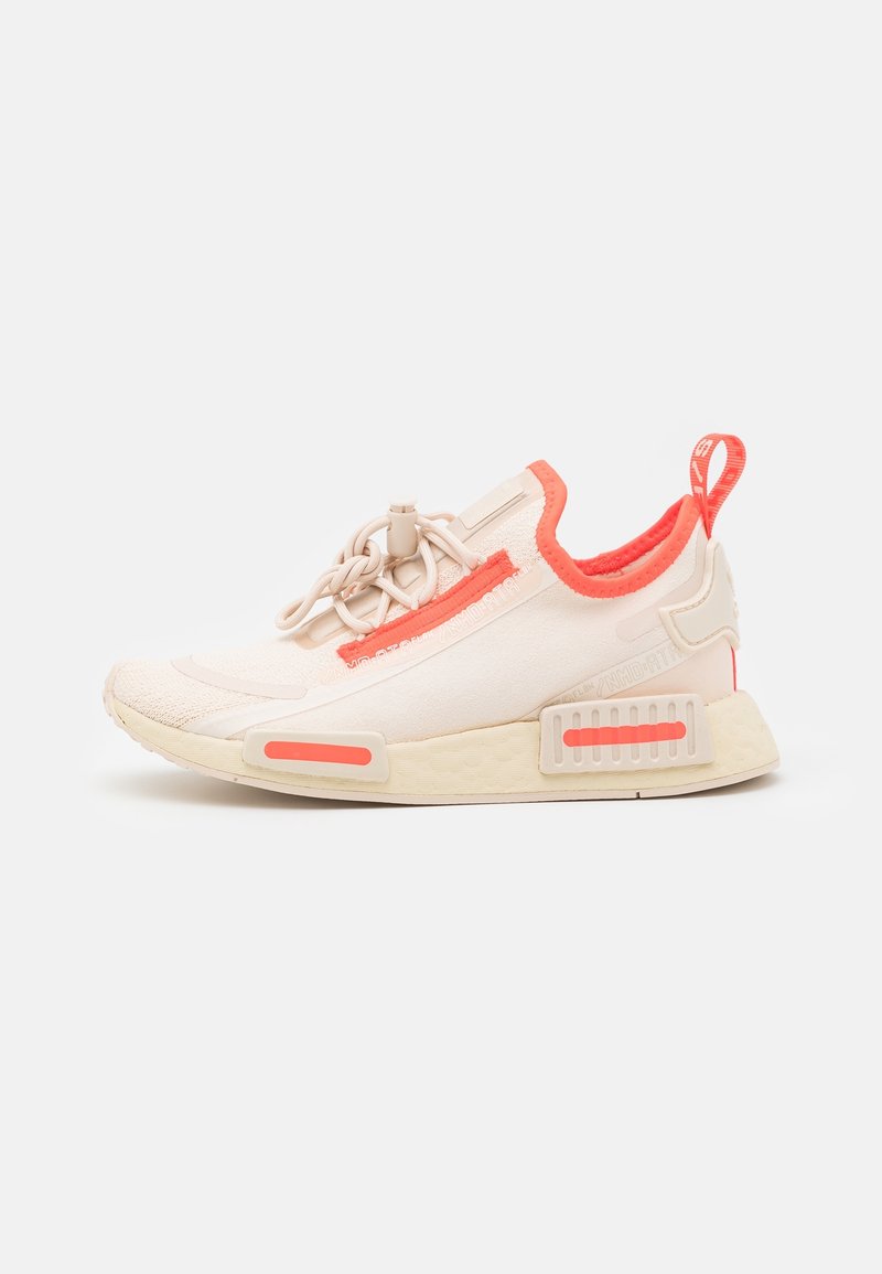 Light beige sneaker with coral accents, featuring a textured upper, elastic laces, and a cushioned sole with distinctive panel details.