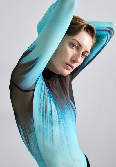 Un body aderente di colore nero e blu sfumato, con maniche lunghe e collo alto, realizzato in un materiale elastico e textured.