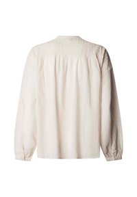 Camisa de manga larga confeccionada en un tejido ligero y texturizado de color crema suave. Presenta detalles fruncidos en los hombros y puños con botones.