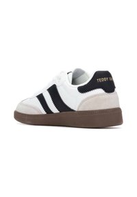 Sneaker bianche con accenti neri e in suede, con tre strisce nere, punta rotonda e suola in gomma marrone. "Teddy Smith" impresso sul tallone.