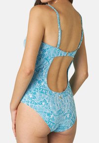 Costume intero turchese con motivo floreale e fogliame bianco, spalline regolabili e design con schiena scoperta. Tessuto con una finitura liscia.
