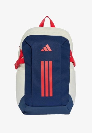 Mochila azul marino y blanca con el logo rojo de Adidas, tres franjas verticales rojas en la parte delantera, hebillas laterales rojas y asa superior para llevar.