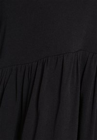 Tessuto nero per abito caratterizzato da una texture liscia, con una cucitura arricciata lungo il fondo che crea una silhouette fluida.
