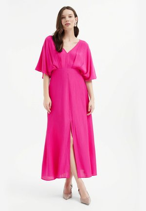 Vibrant pink maxi dress with wide sleeves, V-neckline, and a front slit. Textured fabric with a cinched waist for a flowing silhouette.