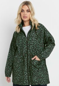 Grön mönstrad vattentät jacka med dragsko i midjan, dragkedjestängning och fickor på sidan; har en hög krage och avslappnad passform.