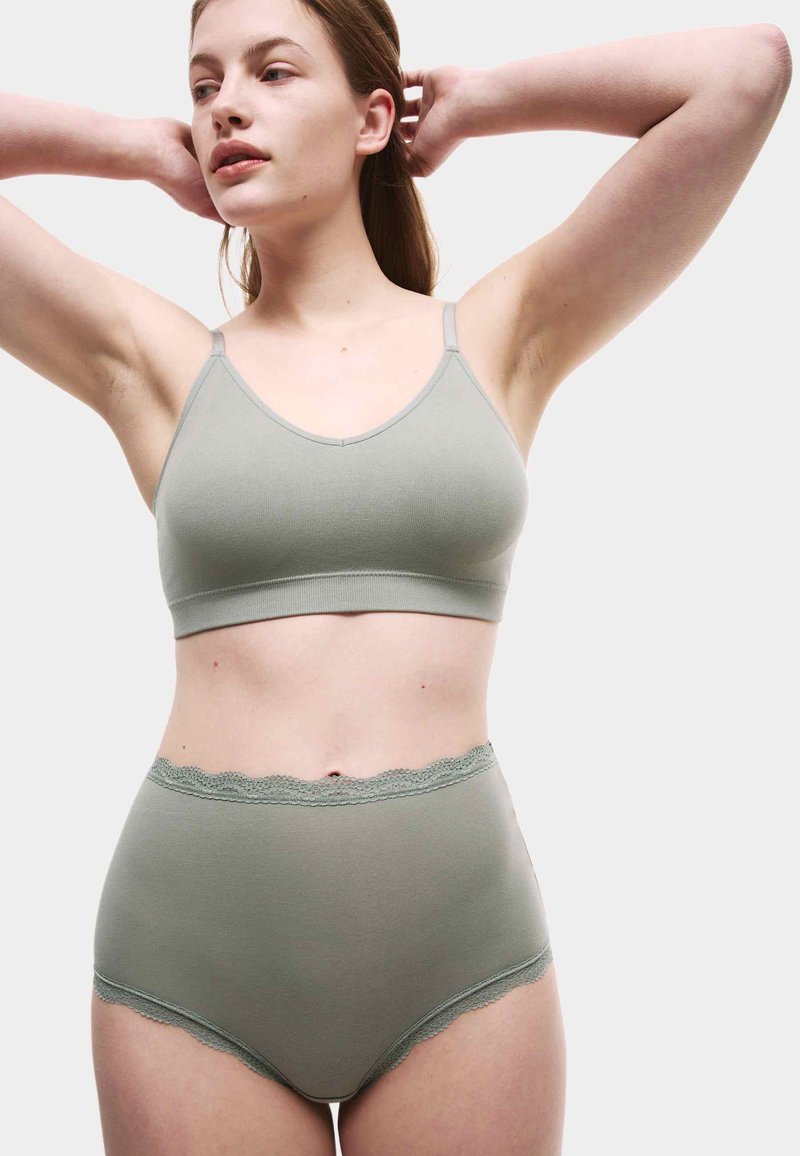 Lys grøn bomuldsbralette med tynde stropper og matchende højtaljede trusser med blonderkanter ved taljen og benåbningerne.