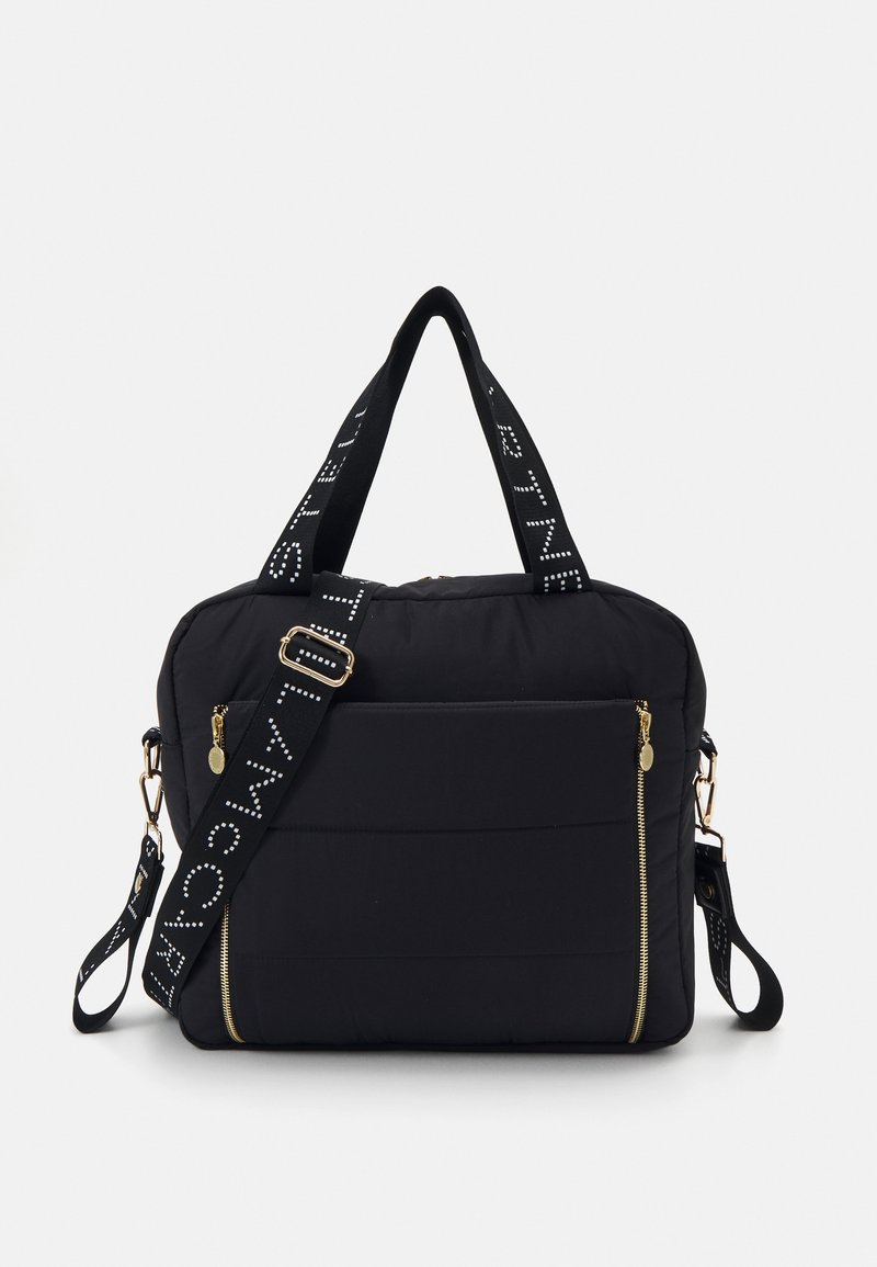 Black quilted handbag features gold zippers, dual top handles, and a detachable strap with white text. Smooth fabric and structured design.