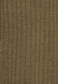 Tissu texturé dans des tons de vert-brun terreux, présentant des motifs côtelés verticaux. Le matériel semble doux et dense, adapté pour le rembourrage ou les vêtements.