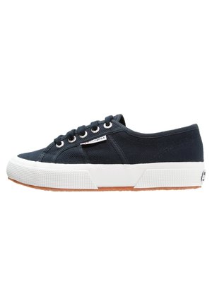 Schwarzer Canvas-Low-Top-Sneaker mit weißer Gummisohle, Schnürung vorne und einem kleinen weißen Logo-Tag an der Seite.