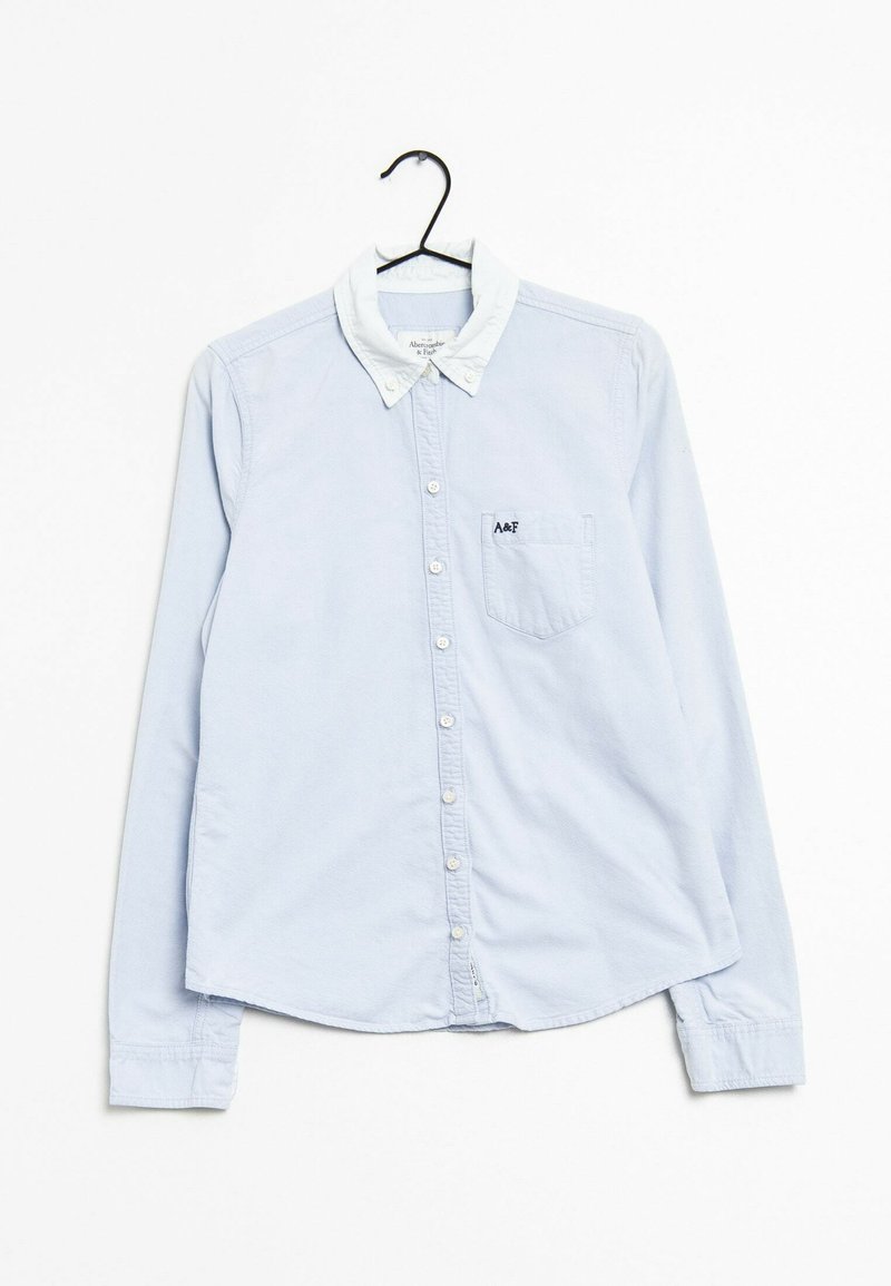 Chemise boutonnée à manches longues bleu clair avec un col blanc, une poche poitrine et un petit logo sur la poche ; fabriquée en tissu doux.