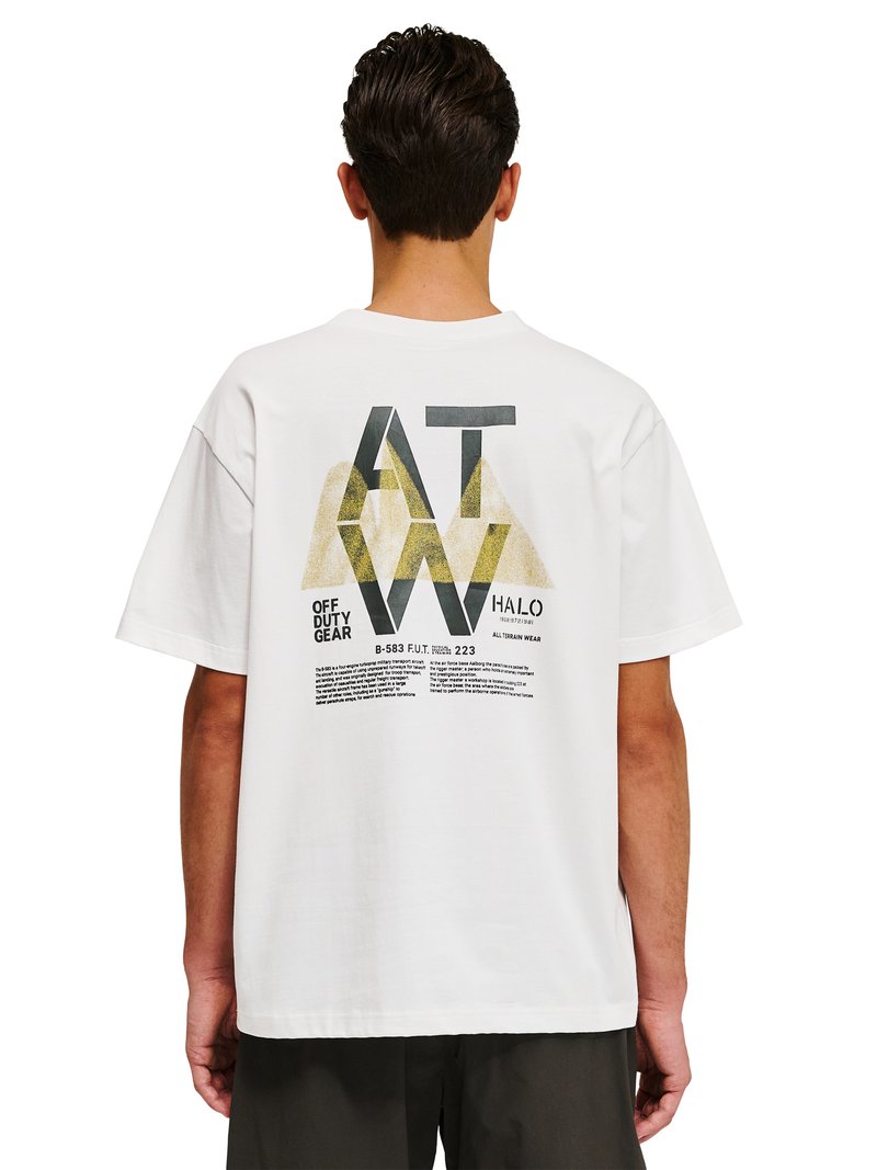 Man facing away wearing a white T-shirt with large black and gold geometric text "AT W" and smaller text "OFF DUTY GEAR" on the back.