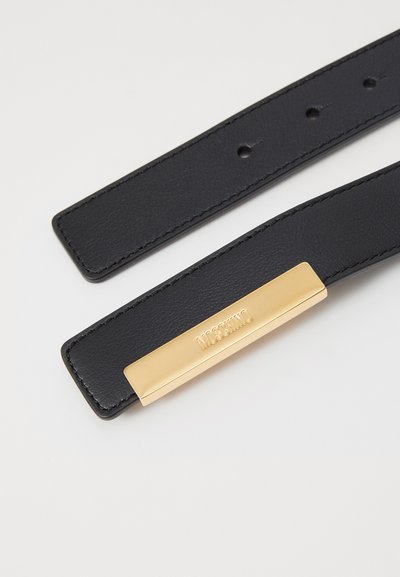 Cinturón de cuero negro con hebilla metálica rectangular en tono dorado con logotipo en relieve. Superficie texturizada y múltiples agujeros para ajuste.