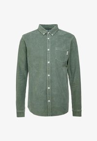 Chemise en velours côtelé verte à manches longues avec poche poitrine devant et col boutonné, présentée sur fond blanc.