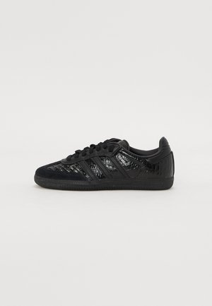 Black leather sneaker with textured pattern, lace-up front, and branded "Samba" label on the side, shown from the inner side.