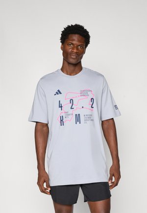 Light gray short-sleeve t-shirt featuring a graphic design with pink and navy blue text. Made of cotton, relaxed fit, and crew neck.